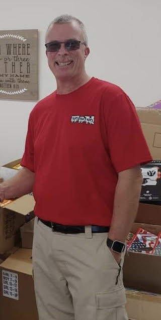 Person wearing a red shirt with a graphic design on the chest.